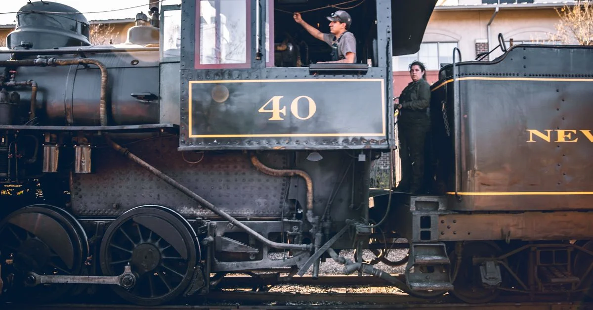 Train à vapeur classique avec équipage, mettant en valeur le charme vintage de la locomotive. Prise de vue en extérieur.